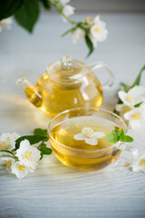 Obraz na płótnie Canvas Composition with cup of jasmine tea and flowers