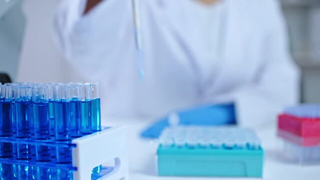 Lab technician adding reagent to flasks with water samples conducting experiment