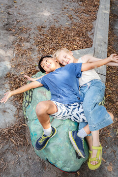 Child friends lying on painted rock