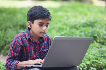 Portrait of Indian boy using laptop while attending the online classes	
