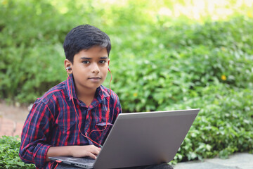Portrait of Indian boy using laptop while attending the online classes	
