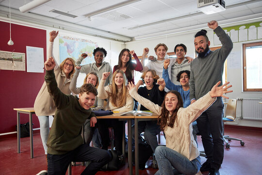 Portrait of students and teachers cheering in class
