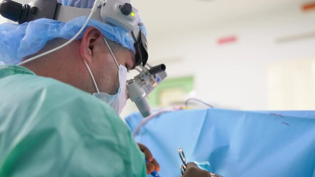 Usage of modern advanced technology at operation. Surgeon wears device glasses at surgery. Close up.