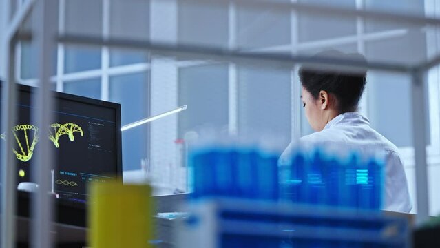 Back view of lab technician working on scientific research, genetic engineering