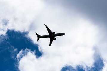 Airplane flying in the sky against a background of clouds.