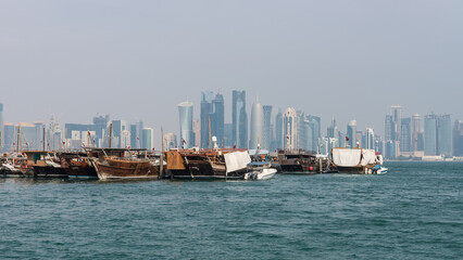 Traditional Qatari dhow on a background of a modern city of West Bay Doha, Qatar. - obrazy, fototapety, plakaty