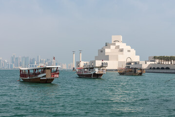 Traditional Qatari dhow on a background of a modern city of West Bay Doha, Qatar.