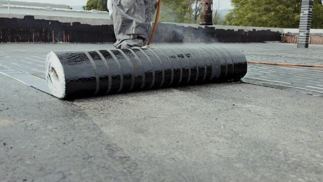 Industrial flat roofing waterproofing system, installed by professionals with a fire burner