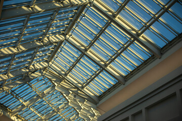 Glass roof in shopping mall. Details of interior in building. Light through glass. Dome in building.