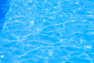 Naklejka na ściany i meble Beautiful blue texture of water. The waves shimmer in the sun. Relax by the pool in summer