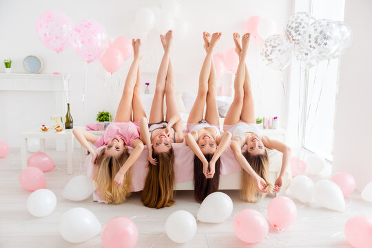 Full Body Photo Of Four Pretty Girls Laying Bed Upside Down Raise Legs Enjoy Celebratory Indoors