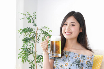 自宅でビールを飲む女性