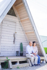Fototapeta premium 別荘の前に座るシニアの夫婦