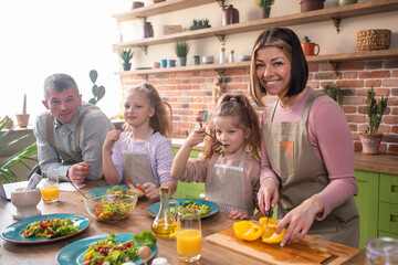 Portrait of cute family cooking together in kitchen