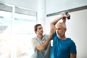 These exercises are very important for your recovery. Shot of a young male physiotherapist helping...