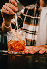 bartender making glass negroni cocktail in bar