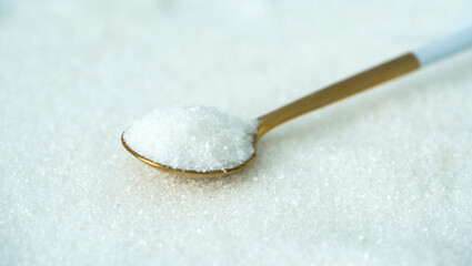 Spoon with sugar on a white background