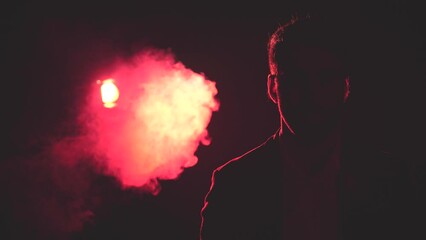 4k slow motion video of man in shadow and smoke and pink light on the background.