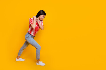 Fototapeta na wymiar Full size profile photo of pretty girl arms pull heavy empty space walk isolated on yellow color background