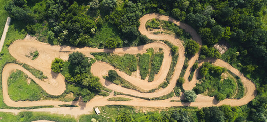 Motocross track in the middle of a green countryside. Horizontal drone shot. High quality photo