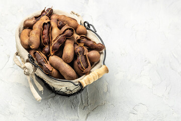 Delicious ripe tamarinds on a basket on a light background, Long banner format. top view