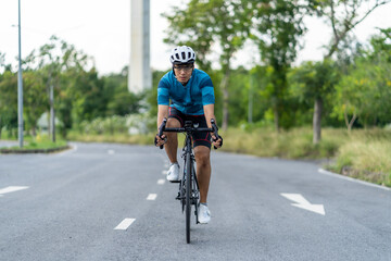 Fototapeta na wymiar Asian man Cyclist Riding On Road Bike In City Park.