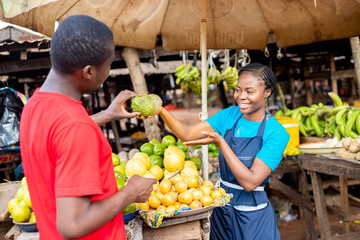 black female farmer selling fruit to a young man