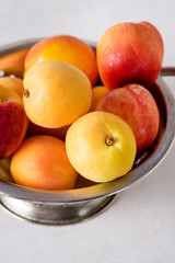 Group of Delicious Freshly Washed Peaches Dripping in a Colander Above Vertical