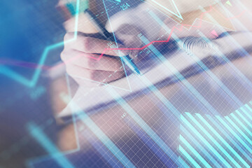 Financial forex graph displayed on hands taking notes background. Concept of research. Double exposure