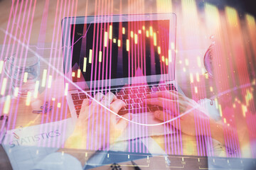 Multi exposure of forex graph with man working on computer on background. Concept of market analysis.