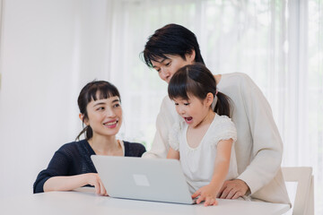 子供と一緒にパソコンで遊ぶ家族