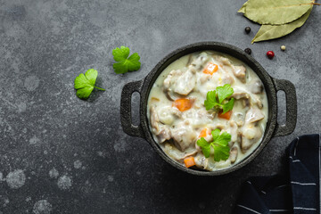 Spicy stewed chicken gizzard, giblets, offal in cast iron pot. Top view, copy space.