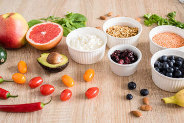 Healthy food concept. Cottage cheese, fruits, vegetables, leaf vegetables, berries, dried fruits and nuts on a wooden table. clean food