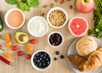 Healthy food concept. Cottage cheese, fruits, vegetables, leaf vegetables, berries, dried fruits and nuts on a wooden table. clean food