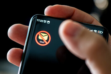 icon of blocked email on a black smartphone screen. The concept of banning email services.