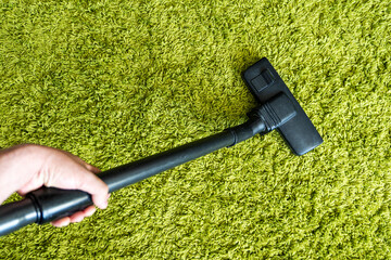 man cleaning carpet. getting rid of dust mites. cleaning the green carpet from dust. Home cleaning...