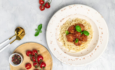 Meatballs served over italian spaghetti pasta with tomato sauce on a light background. Italian food. banner, menu, recipe place for text, top view