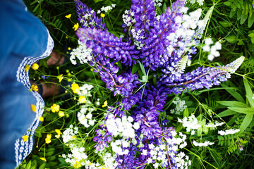 woman's feets and beautiful bouquet of  autumn flowers in wicker basket