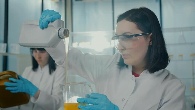 close-up portrait of a scientist woman in a modern laboratory pours oil slow mo