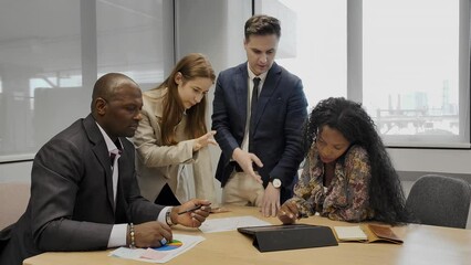 Creative business team meeting in modern start up office female team leader pointing at screen discussing diverse people group teamwork