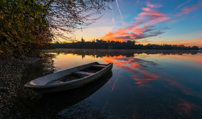 Obraz premium Autumn colors by the lake with a boat
