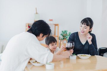 Fototapeta premium 子供と一緒に乾杯をする家族