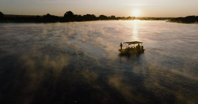 Close-up aerial sunset view of a tourist boat fishing on the Zambezi River