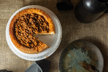 typical brazilian churros cake with dulce de leche, on a table with plates and coffee, comfortable breakfast or snack scene