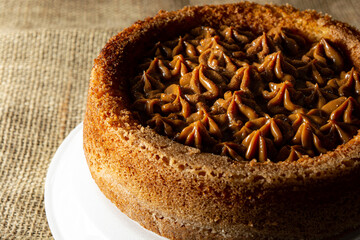 typical brazilian churros cake with dulce de leche, on a table with plates and coffee, comfortable breakfast or snack scene