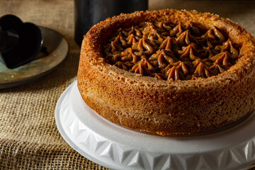 typical brazilian churros cake with dulce de leche, on a table with plates and coffee, comfortable breakfast or snack scene
