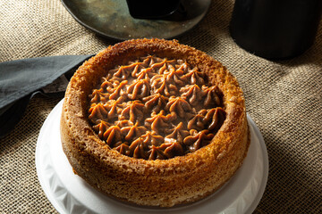 typical brazilian churros cake with dulce de leche, on a table with plates and coffee, comfortable breakfast or snack scene