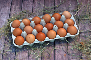 Eier in einer Eierschachtel auf rustikalem Holzhintergrund.