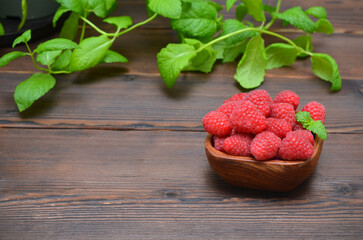 fresh raspberries and mint leaves on a wooden table