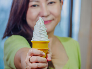 Asian young woman showing vanilla and chocolate ice cream and eating deliciously in summer with have fun and good mood.